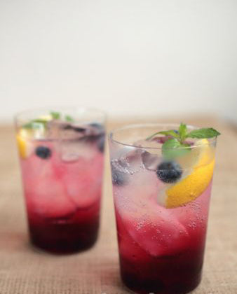 Two glasses of punch with fruit in it